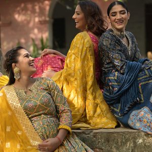 Three beautiful women sitting together wearing latest Anarkali Suits by Kalki Fashion pictured on an outdoor location